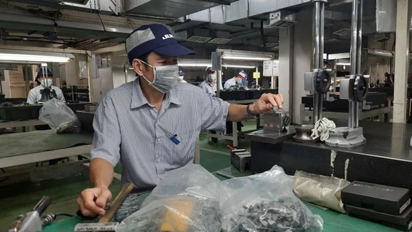 Công nhân Công ty trách nhiệm hữu hạn Juki Việt Nam, Khu Chế xuất Tân Thuận, Thành phố Hồ Chí Minh đang sản xuất các linh kiện máy may công nghiệp.