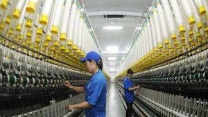 Công nhân Công ty TNHH một thành viên Dệt 8-3 vận hành dây chuyền sản xuất sợi. (Ảnh: TRẦN HẢI)