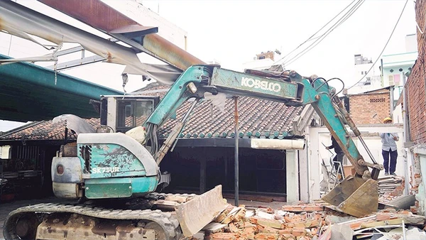 Lực lượng chức năng tháo dỡ công trình xây dựng trái phép tại phường Bình Thạnh. (Ảnh THẾ ANH)