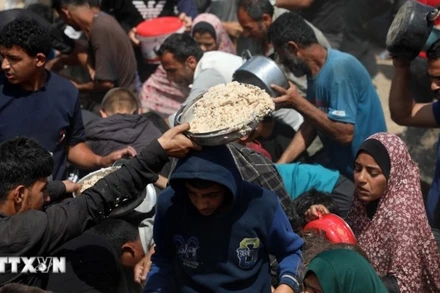 Người dân nhận thực phẩm cứu trợ tại Gaza. (Ảnh: THX/TTXVN)