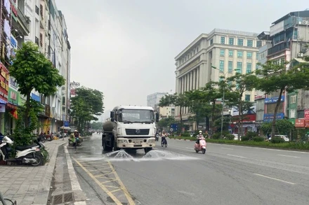 Xe phun nước làm sạch mặt đường tại phố Xã Đàn.