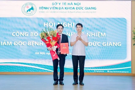 Phó Giám đốc Sở Y tế Hà Nội Vũ Cao Cương trao quyết định và tặng hoa chúc mừng tân Giám đốc Bệnh viện Đa khoa Đức Giang Đỗ Đình Tùng.