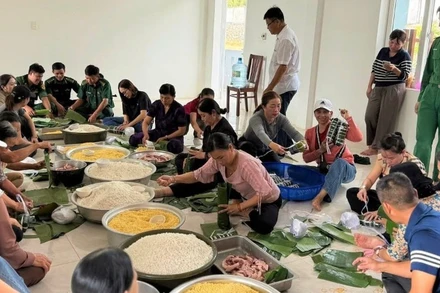 Bộ đội Biên phòng và người dân gói bánh tét gửi ra miền trung. (Ảnh: CTV)