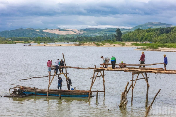 Người dân xây dựng lại cầu gỗ Ông Cọp sau khi công trình bị lũ cuốn đi vào tháng 11 vừa qua.