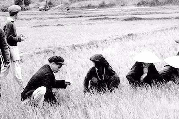 Bí thư Kim Ngọc (người đội mũ ngồi bên trái) với nông dân.