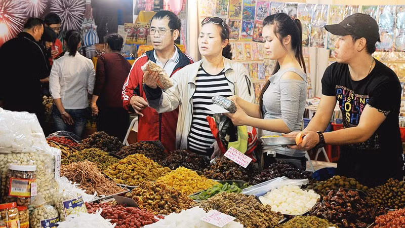 Người tiêu dùng lựa chọn các loại bánh mứt kẹo được bán trên thị trường. Ảnh: NGUYỆT ANH