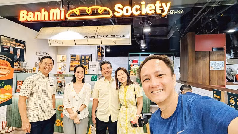 Chị Quỳnh (thứ hai, trái sang) tại tiệm bánh mì Việt Nam ở Singapore.