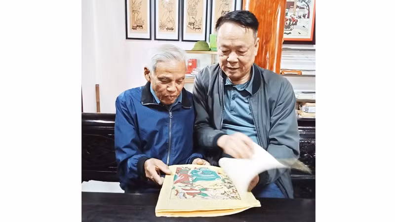 Nghệ nhân Nguyễn Đăng Chế giới thiệu với tác giả bài viết bộ sưu tập tranh dân gian Đông Hồ.