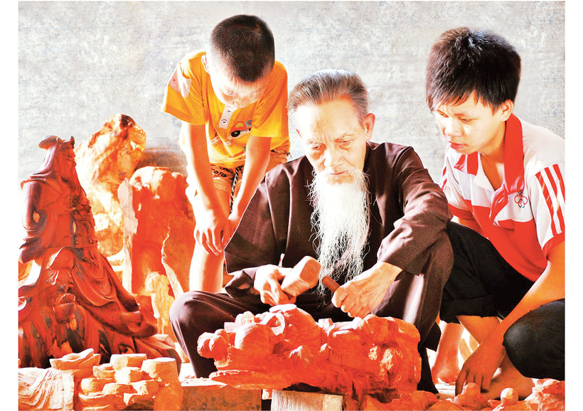 Nghệ nhân làng nghề gỗ mỹ nghệ Thiết Úng truyền nghề cho con, cháu. Ảnh: Đỗ Phong 