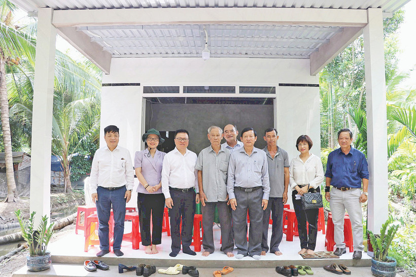 Lãnh đạo Báo Nhân Dân chụp ảnh lưu niệm trong một lần tặng quà hỗ trợ xây dựng nhà “Đại đoàn kết” khu vực Đồng bằng sông Cửu Long. Ảnh: BÁ DŨNG