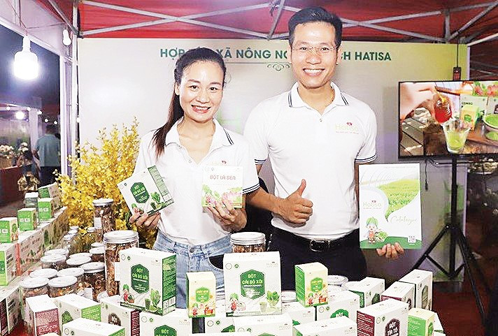 Anh Nguyễn Mạnh Tường, Giám đốc Hợp tác xã Nông nghiệp sạch Hatisa (bên phải) giới thiệu sản phẩm. Ảnh: Ngọc Khánh