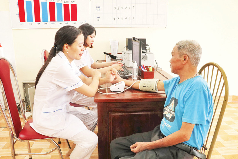 Các y bác sĩ tại Trạm y tế xã Gia Thủy cũ (xã Nho Quan mới), tỉnh Ninh Bình kiểm tra sức khỏe cho người bệnh. Ảnh: TTXVN