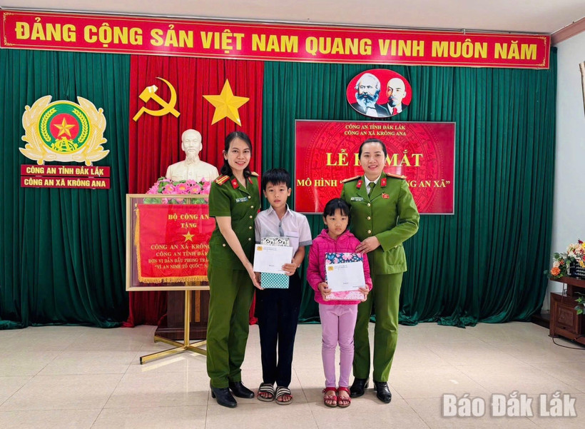 Đại diện Công an xã Krông Ana tặng quà cho con nuôi Đặng Hải Đăng và Hoàng Bảo Ngọc.