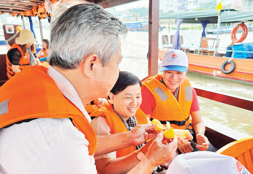 Du khách thưởng thức sản vật trên chợ nổi Cái Răng. Ảnh: Nam Anh