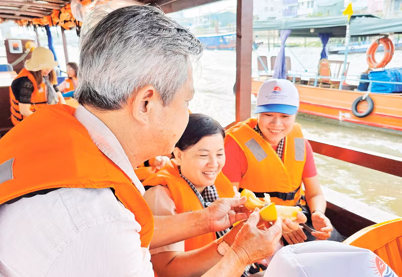 Du khách thưởng thức sản vật trên chợ nổi Cái Răng. Ảnh: Nam Anh