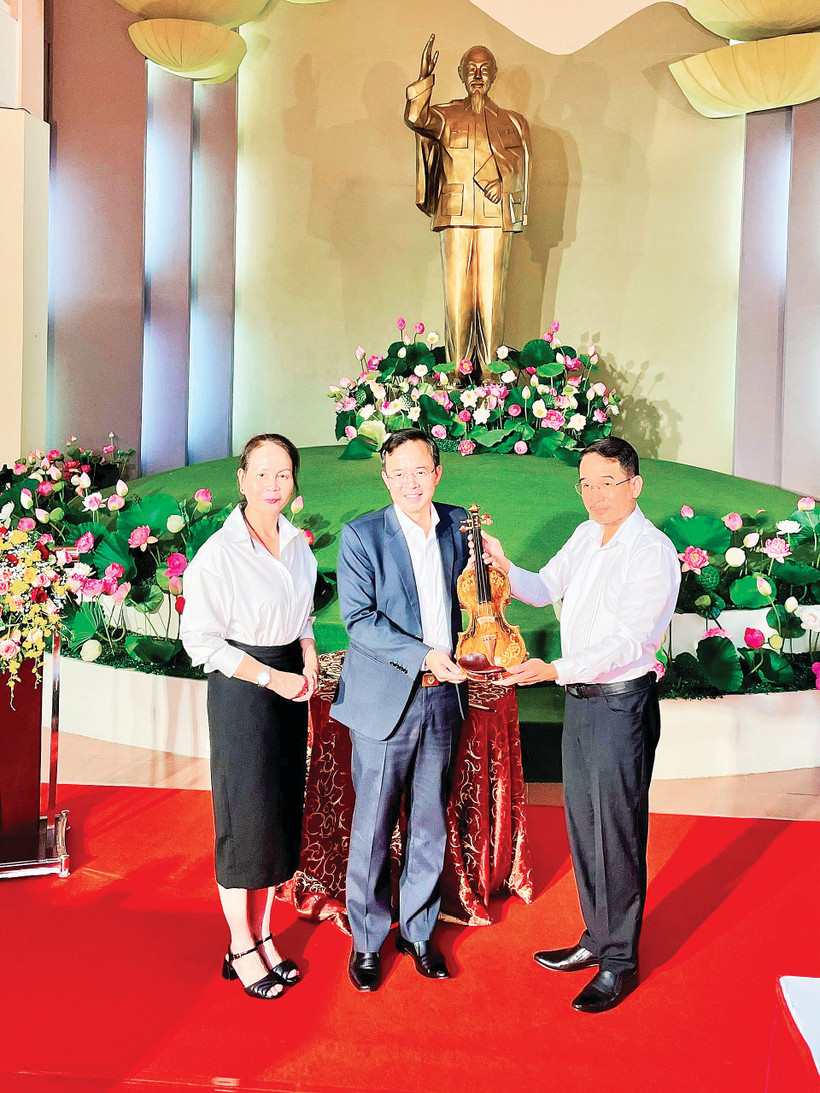 Nghệ sĩ Nguyễn Xuân Huy trao cây đàn violin bằng sứ cho lãnh đạo Sở Văn hóa, Thể thao và Du lịch tỉnh Lâm Đồng.