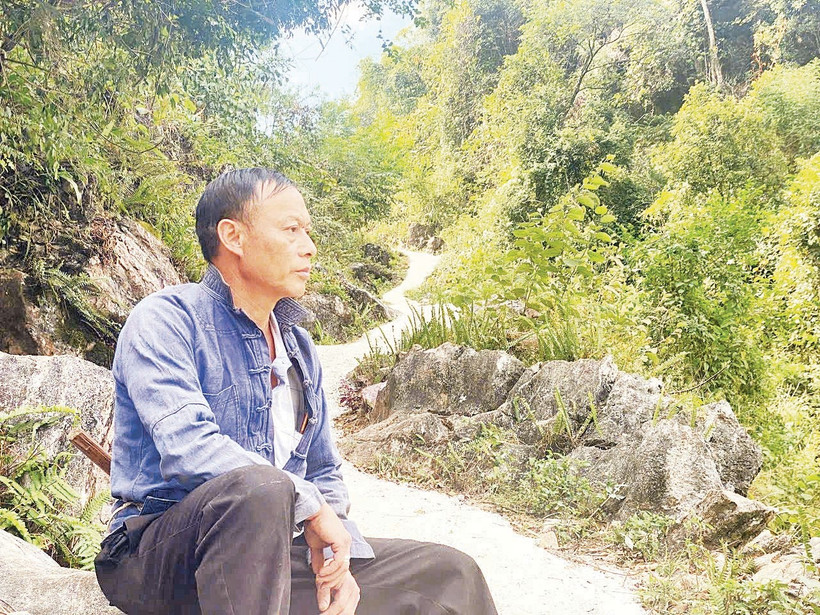 Bí thư Chi bộ Thào A Quả bên một đoạn đường anh đã vận động bà con chung sức hoàn thành. Ảnh: Doãn Hoàng 