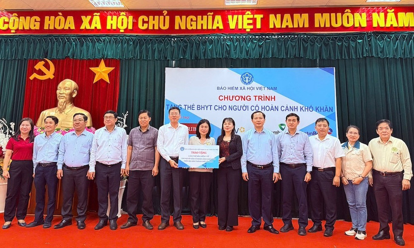 Trao biểu trưng tặng thẻ BHYT cho người dân.