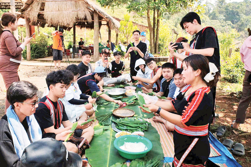 Hướng dẫn du khách trải nghiệm gói bánh dân tộc.
