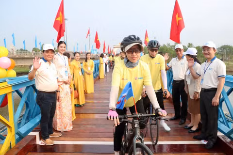 Các vận động viên đạp xe diễu hành qua cầu Hiền Lương.