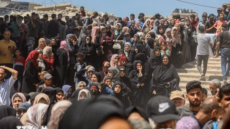 Người dân Palestine chờ được phát thực phẩm cứu trợ tại Gaza. (Ảnh: THX/TTXVN)