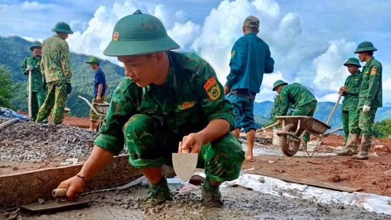 Chiến sĩ Ban Chỉ huy Bộ đội Biên phòng tỉnh Điện Biên giúp người dân bản Háng Pù Xi, xã Xa Dung làm nhà ở mới sau lũ quét