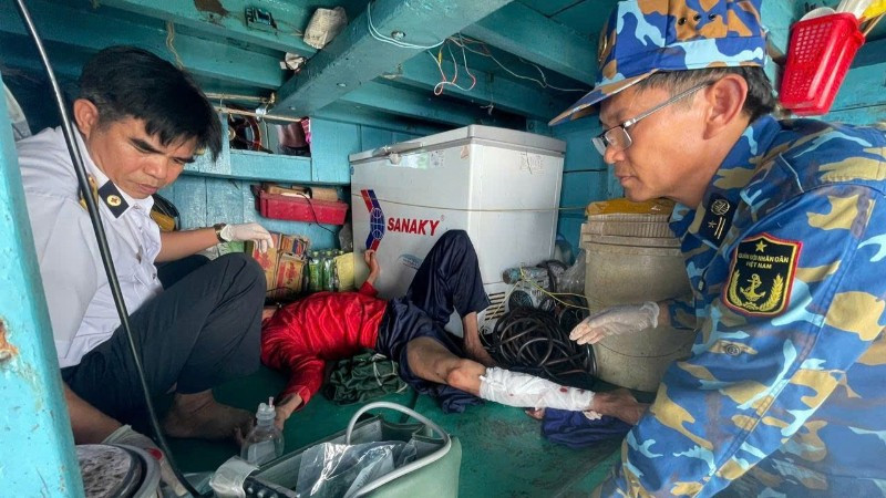 Quân y nhà giàn tiếp cận và vệ sinh, băng bó chân gãy cho nạn nhân.