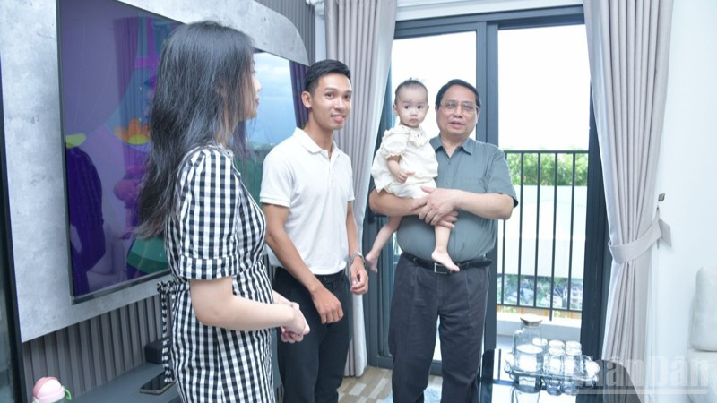 Thủ tướng Phạm Minh Chính hỏi thăm cuộc sống của một hộ gia đình trẻ sống trong khu nhà ở xã hội. (Ảnh: THANH GIANG) ndo_br_a3-4584.jpg
