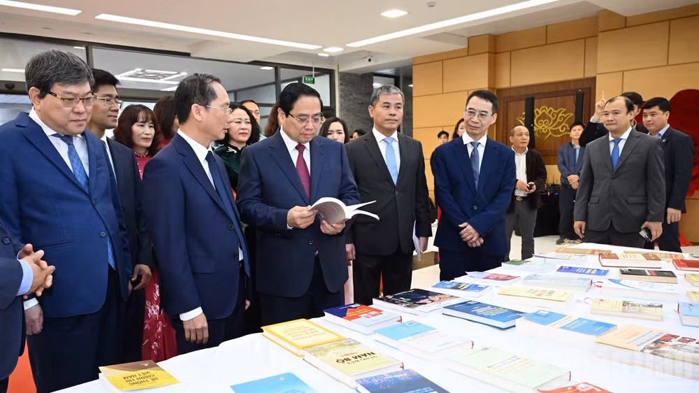 Thủ tướng Phạm Minh Chính tham quan khu trưng bày sách và giới thiệu về các hoạt động của Học viện Hành chính và Quản trị công. (Ảnh: Trần Hải)