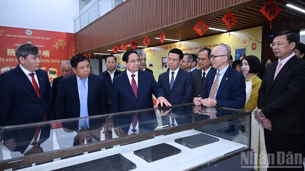 Thủ tướng Phạm Minh Chính nghe giới thiệu về những thành tựu của Viện Hàn lâm Khoa học xã hội Việt Nam. (Ảnh: TRẦN HẢI)