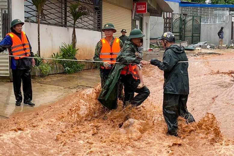 Lực lượng chức năng đưa người dân ra khỏi vùng nguy hiểm. (Ảnh: VGP)