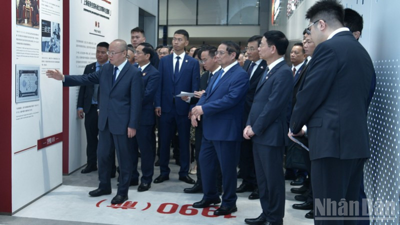 Thủ tướng Phạm Minh Chính nghe giới thiệu về lịch sử phát triển của thị trường chứng khoán Thượng Hải. (Ảnh: Thanh Giang) ndo_br_a4-576.jpg