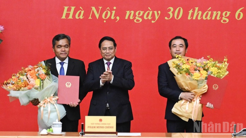 Thủ tướng Chính phủ Phạm Minh Chính trao Quyết định bổ nhiệm và tặng hoa chúc mừng hai đồng chí Trần Đức Thắng và Hồ Văn Niên. (Ảnh: TRẦN HẢI)