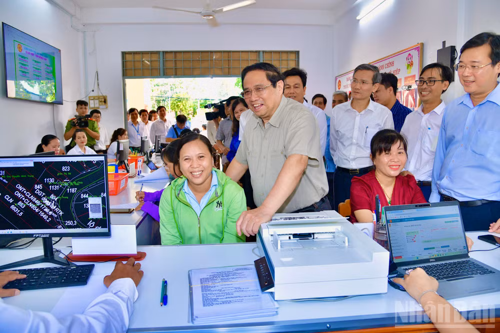 Thủ tướng Phạm Minh Chính hỏi thăm một người dân ở xã Mỹ Hiệp đến làm thủ tục hành chính tại Trung tâm Phục vụ hành chính công. (Ảnh: THANH GIANG)