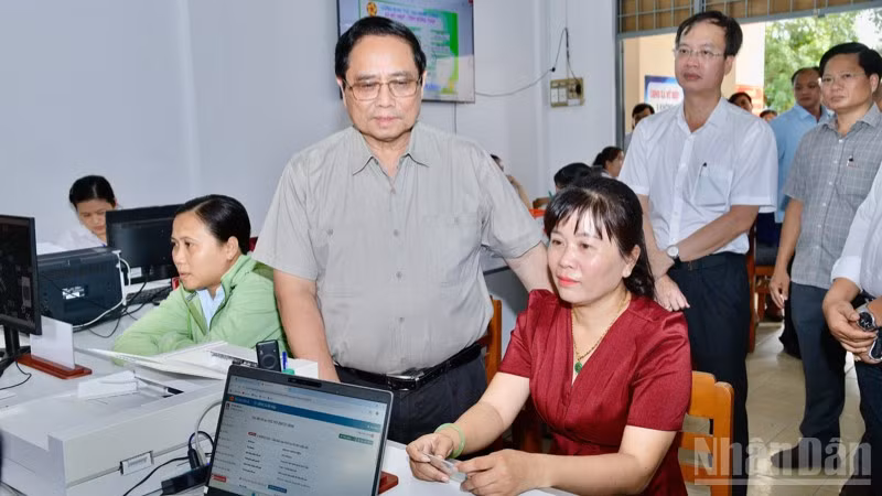 Thủ tướng Phạm Minh Chính hỏi thăm người dân đến làm thủ tục hành chính. (Ảnh: THANH GIANG)