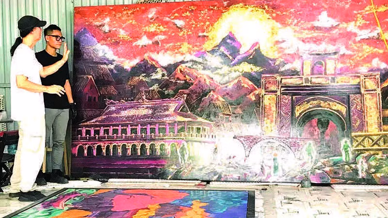 Họa sĩ Chu Nhật Quang và cha là Nghệ sĩ Ưu tú Chu Lượng trao đổi tại xưởng tranh sơn mài “Mùa xuân Độc lập".