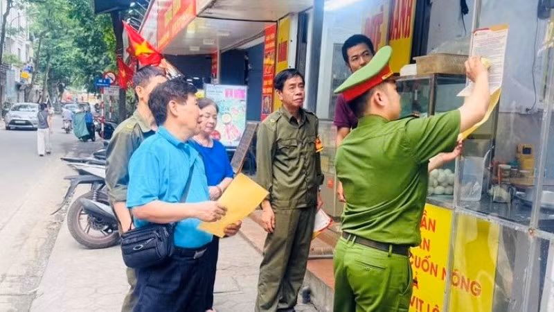 Lực lượng chức năng phường Láng hướng dẫn người dân chấp hành trật tự đô thị.