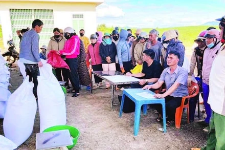 Người dân xã Ngọk Bay đến nhận gạo cứu trợ. (Ảnh PHÚC THẮNG)