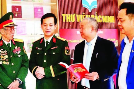 Giám đốc Thư viện Bắc Ninh số 1 Nguyễn Đắc Hồng (thứ hai, từ phải sang) trao đổi với độc giả tại một cuộc trưng bày sách.