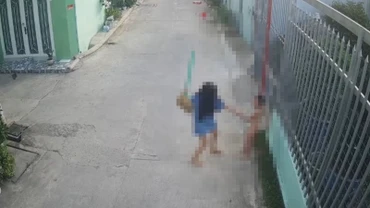 Bà Trang dùng chổi đánh cháu T. (Ảnh cắt từ camera)