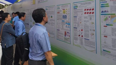 Các đại biểu tìm hiểu các báo cáo bằng poster trưng bày tại hội nghị.