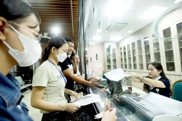 Người dân nộp tiền khám sức khỏe tại Bệnh viện Bạch Mai, Hà Nội. (Ảnh NGUYỄN KHÁNH)