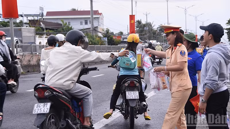 Các đơn vị, đoàn thể xã Châu Thành phát nước suối và khăn lạnh cho người dân về quê nghỉ lễ.