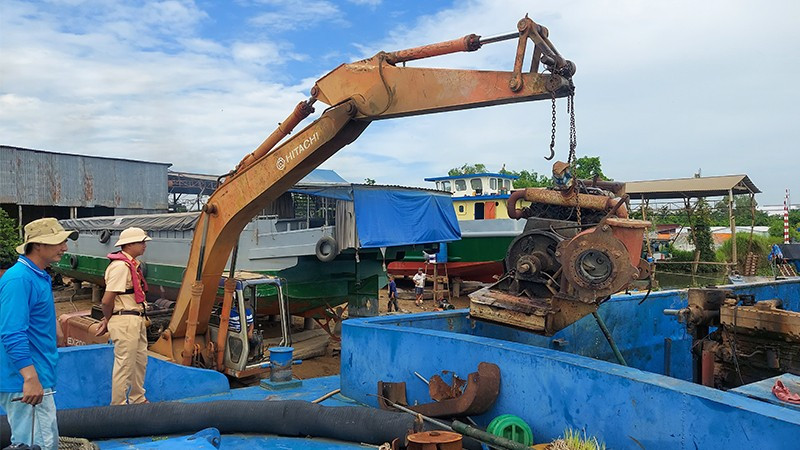 Đội Cảnh sát giao thông đường thủy thuộc Phòng Cảnh sát giao thông Công an tỉnh cho chủ phương tiện tự nguyện tháo gỡ thiết bị bơm hút cát, sỏi. (Ảnh: Công an cung cấp) dt5.jpg