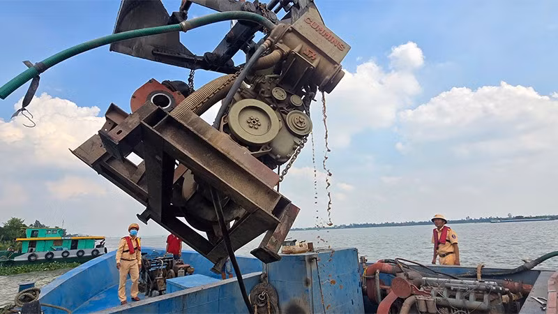 Trạm Cảnh sát giao thông đường thủy Sa Đéc thuộc Phòng Cảnh sát giao thông Công an tỉnh cho chủ phương tiện tự nguyện tháo gỡ thiết bị bơm hút cát, sỏi. (Ảnh: Công an Đồng Tháp)