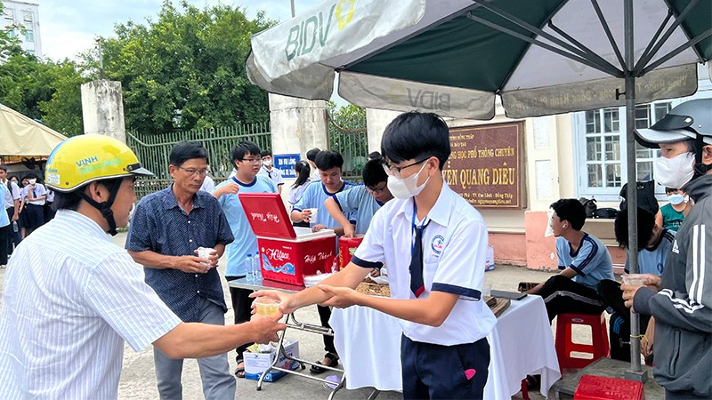 Học sinh Trường trung học phổ thông chuyên Nguyễn Quang Diêu tự pha nước uống tặng phụ huynh chờ con thi ra. (Ảnh: HỮU NGHĨA) ts1.jpg