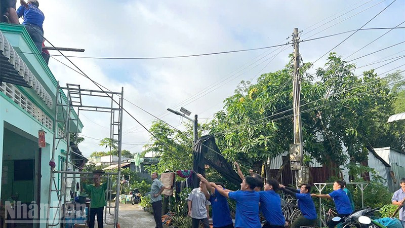 Chính quyền địa phương xã Tân Khánh Trung cùng bà con dọn dẹp, khắc phục hậu quả sau dông lốc, mưa lớn.