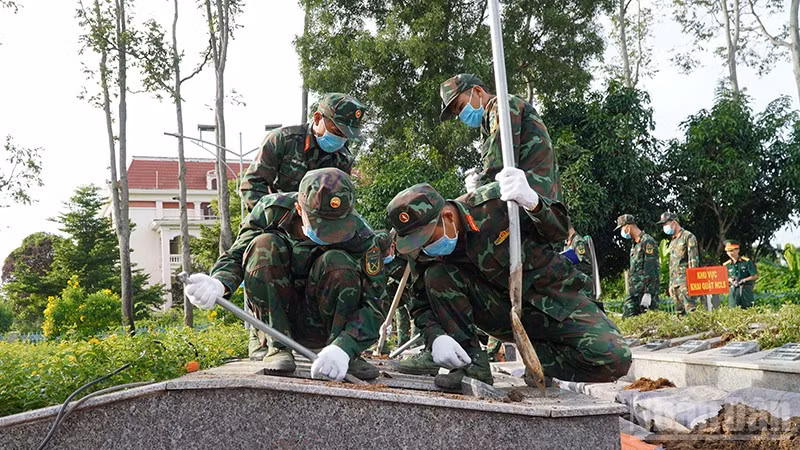 Lực lượng chức năng tiến hành khai quật để lấy mẫu hài cốt liệt sĩ. (Ảnh: HỮU NGHĨA)
