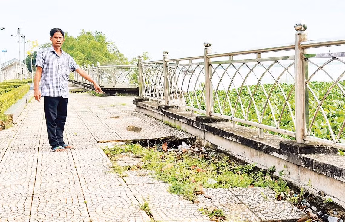 Người dân chỉ nơi sụt lún kè sông Cổ Chiên đoạn phường Tân Ngãi, tỉnh Vĩnh Long.