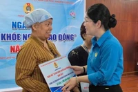 Bà Nguyễn Kim Loan, Phó Chủ tịch Liên đoàn Lao động Thành phố Hồ Chí Minh tặng quà cho lao động nữ bị bệnh hiểm nghèo. (Ảnh: Mai Chi) 